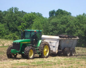 tractor distributing biosolids