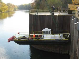lowering hydraulic dredge into a river