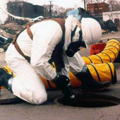 Crew cleaning out pipeline through a manhole